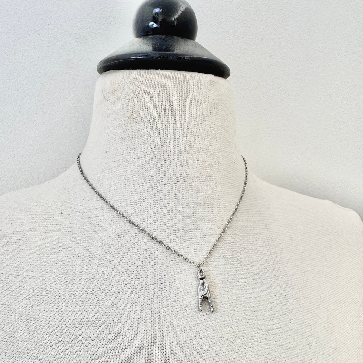 Dainty FOXLARK Rock On hand charm pendant necklace showcasing a bold hand gesture for confident, stylish wear.