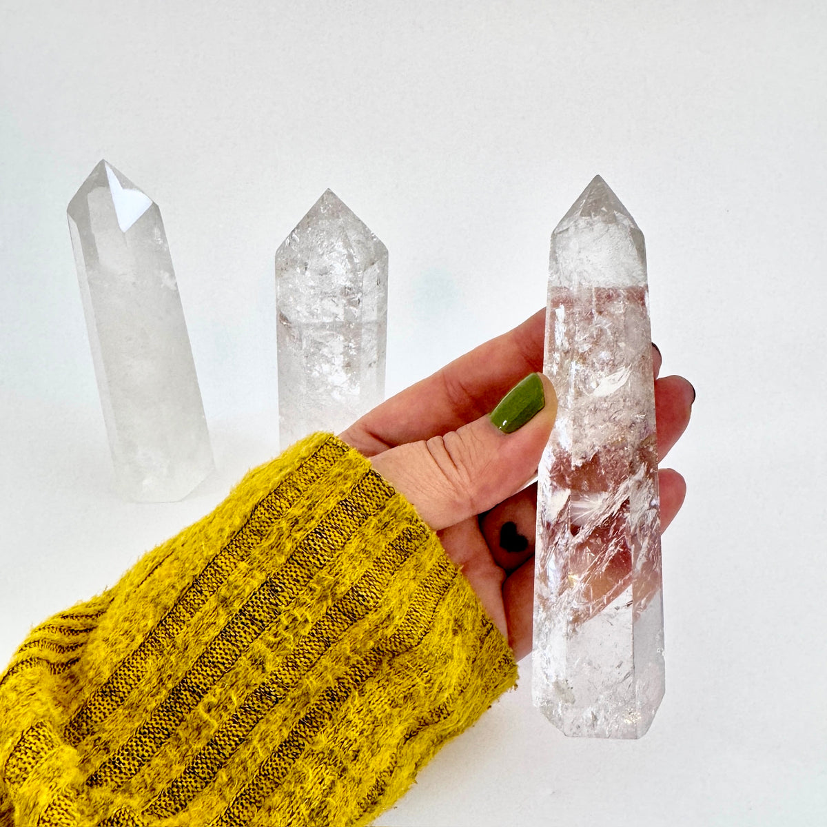 Self-standing clear quartz crystal point from FOXLARK, showcasing its natural transparent crystal formation and pointed shape.
