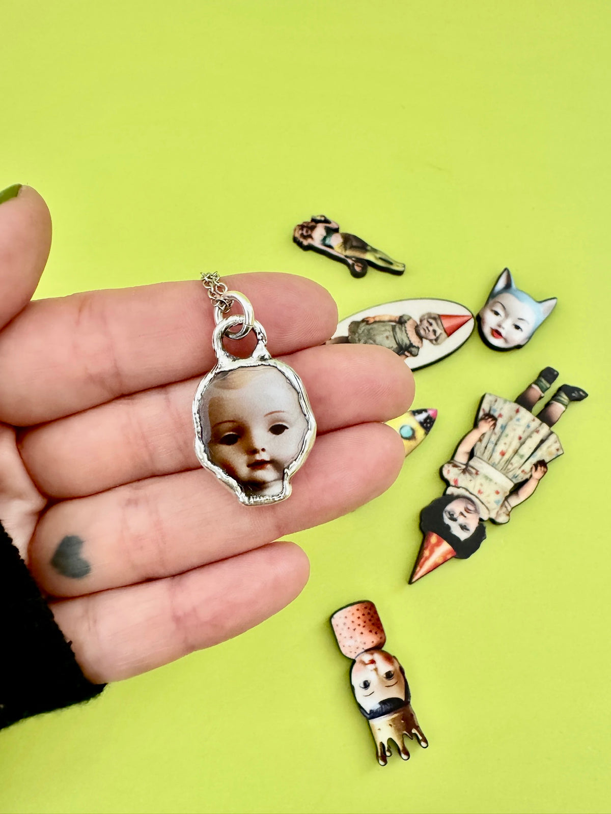 Doll head necklace in fine silver from FOXLARK's Weirdlings Collection, showcasing a detailed silver doll head pendant.