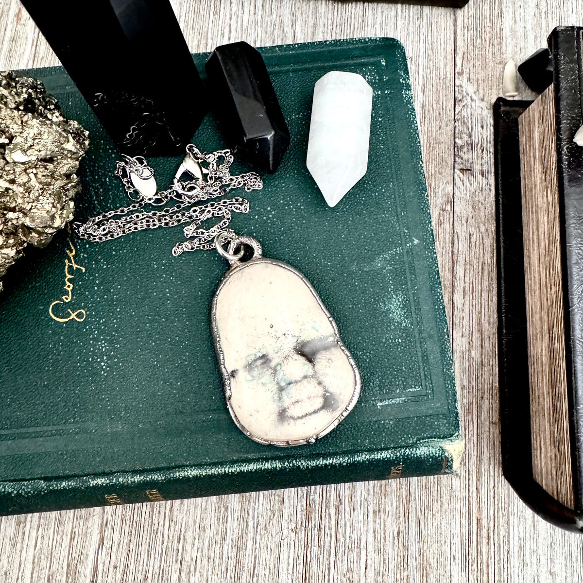 Fine silver ceramic baby doll face necklace from FOXLARK collection, featuring detailed, handcrafted jewelry design.