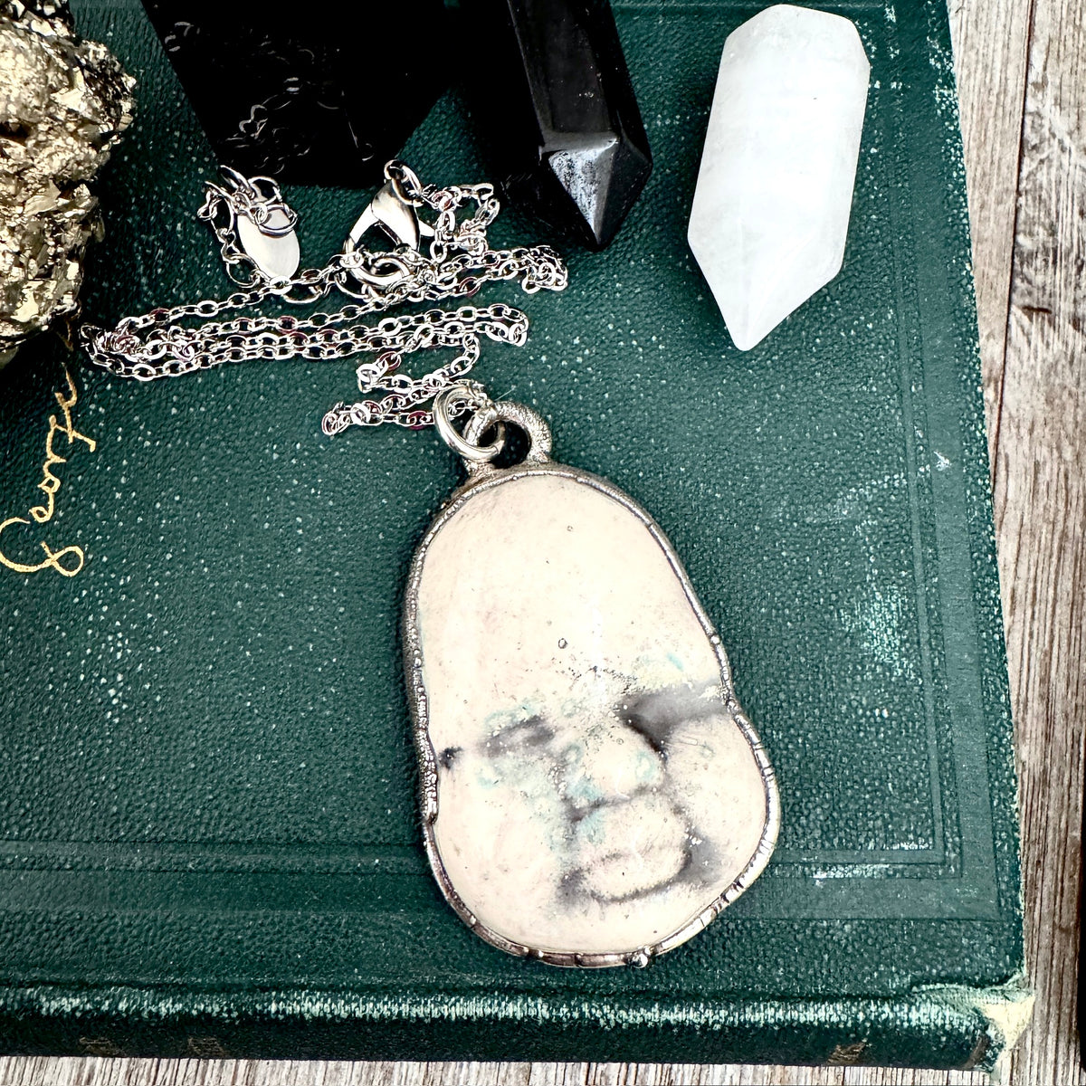 Ceramic baby doll face necklace from FOXLARK Collection, fine silver finish, unique handcrafted jewelry.