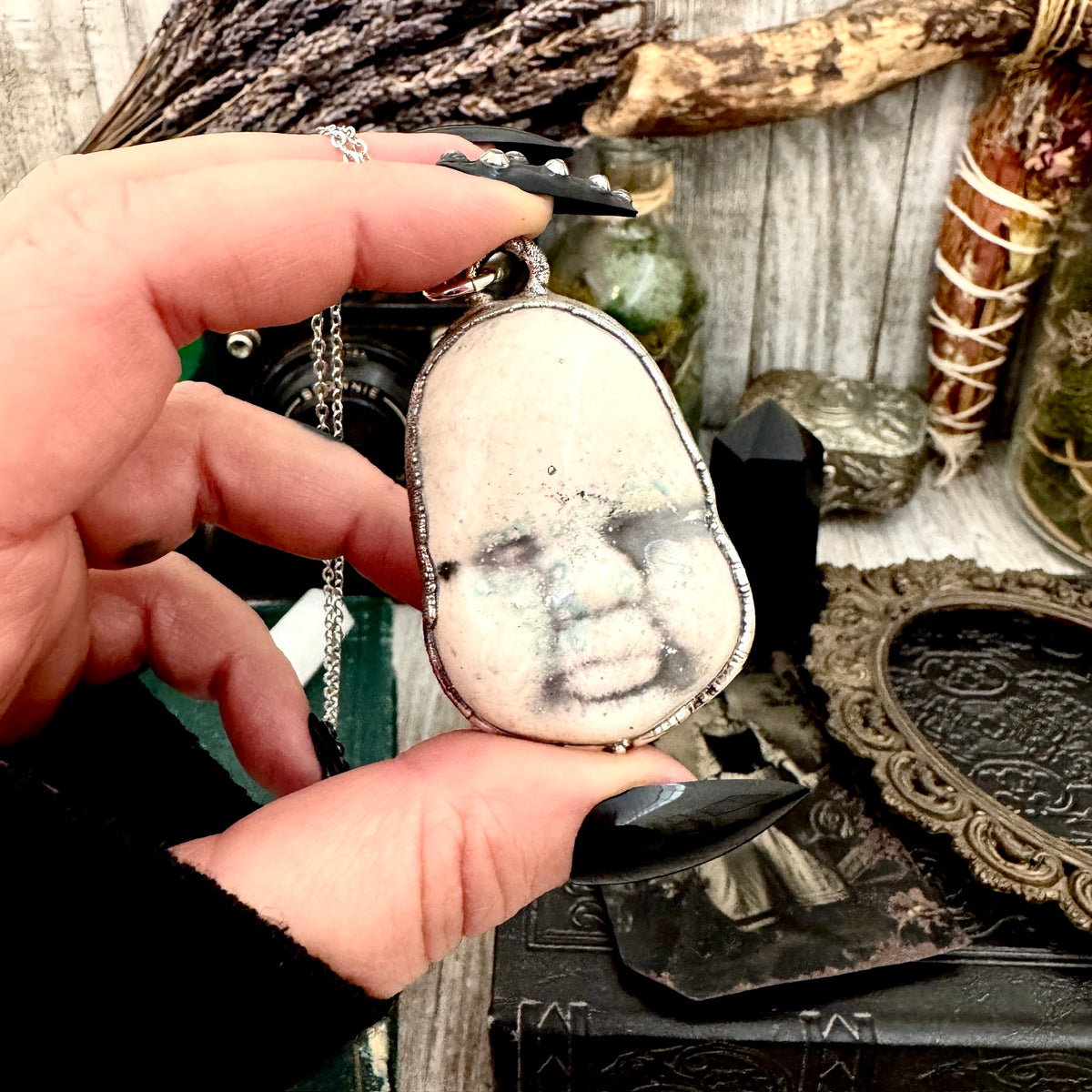 Fine silver ceramic baby doll face necklace from FOXLARK collection, showcasing detailed craftsmanship and unique design.