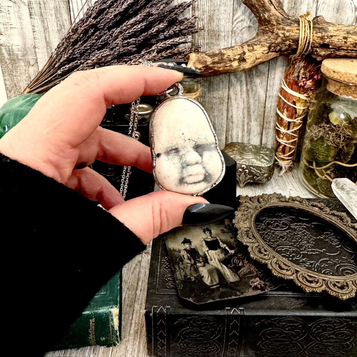 Fine silver ceramic baby doll face necklace from FOXLARK collection, showcasing a unique and detailed handcrafted jewelry piece.