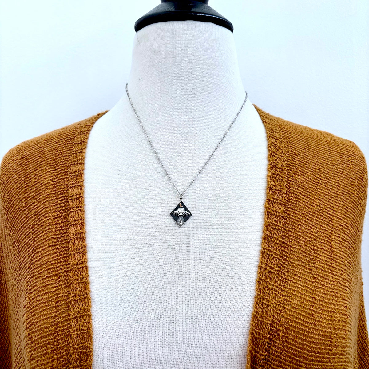 Sterling silver UFO abduction necklace pendant from FOXLARK Tiny Talisman Collection, featuring a small, detailed alien spacecraft design.