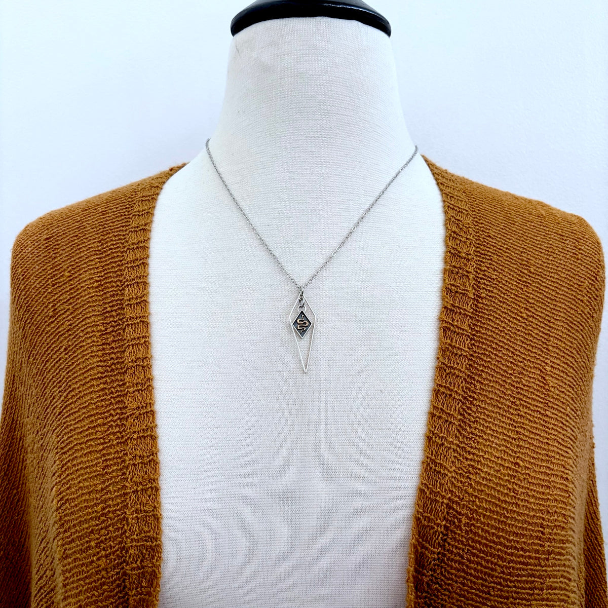 Tiny sterling silver snake talisman necklace from FOXLARK's Talisman Collection featuring a detailed diamond-shaped snake charm.