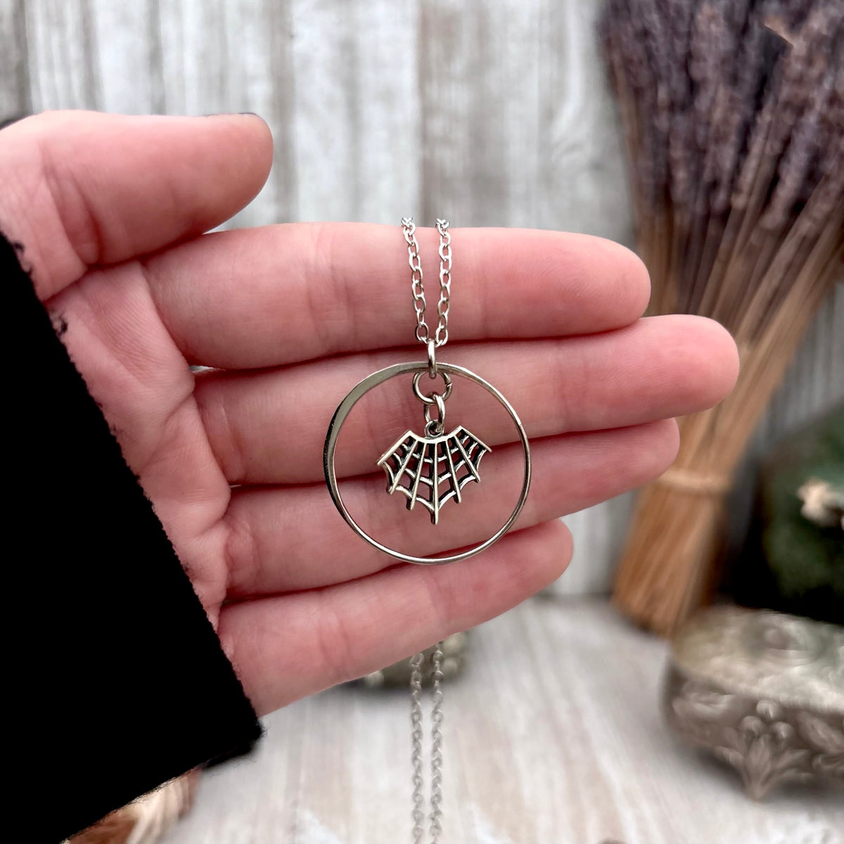 Tiny sterling silver spider web talisman necklace from FOXLARK's Talisman Collection, featuring detailed web design.