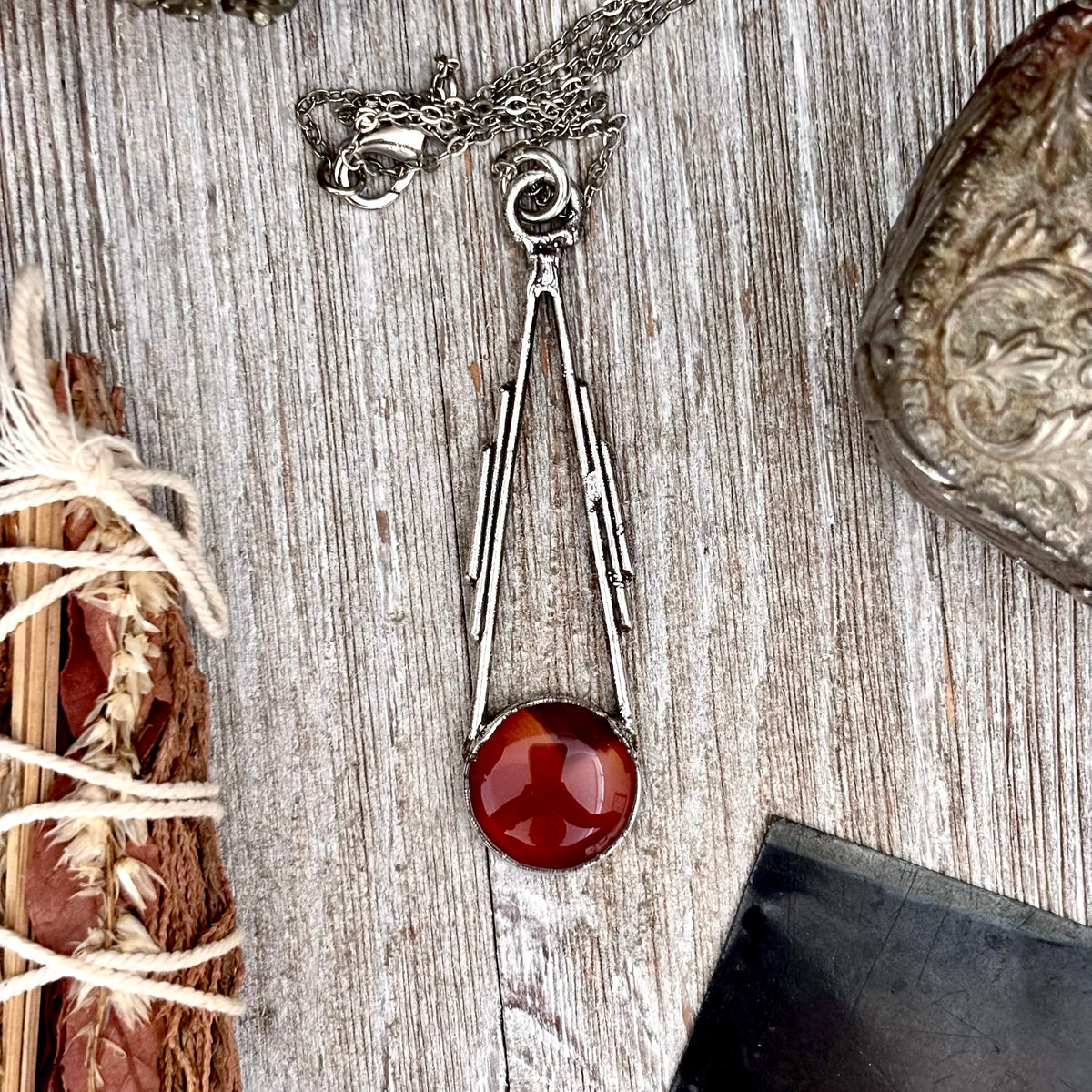 Red carnelian crystal necklace by FOXLARK with fine silver setting, showcasing a vibrant polished gemstone on a delicate chain.