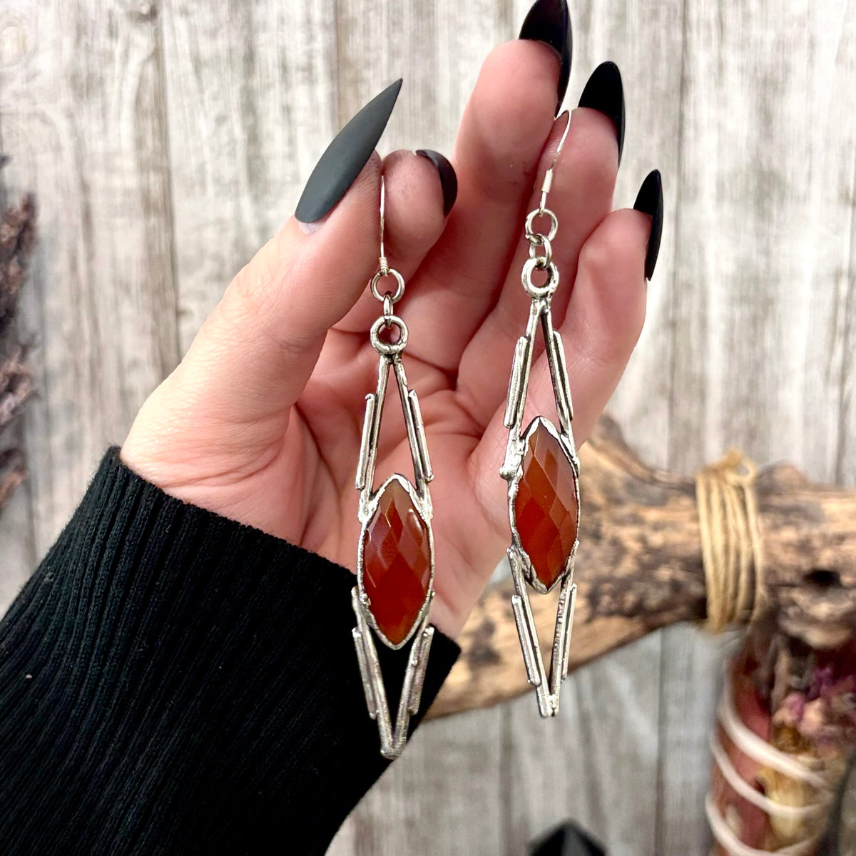 Carnelian and silver crystal dangle earrings by FOXLARK featuring long, witchy-style needle-shaped design and intricate detailing.