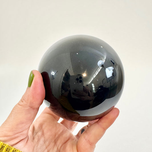 Large black obsidian crystal ball from FoxlarkCrystals, polished and smooth, showcasing deep black volcanic glass.