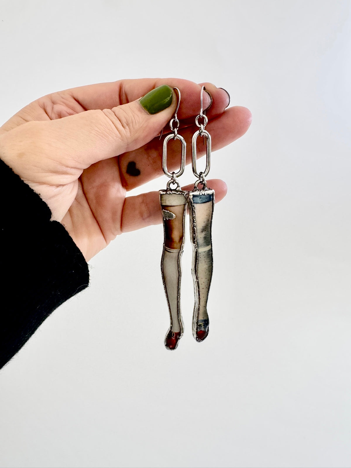 Long silver mismatched doll leg earrings with dangle design from FOXLARK's The Weirdlings Collection, statement jewelry for bold style.