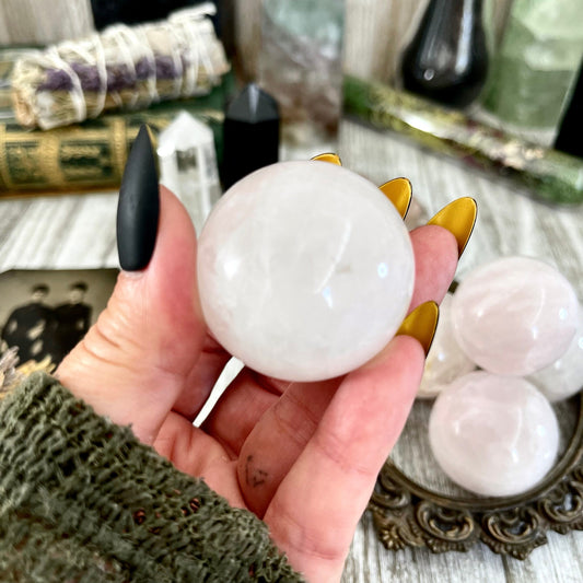 Small rose quartz crystal sphere from FoxlarkCrystals showing a polished pink gemstone with smooth, rounded surface and subtle crystal details.