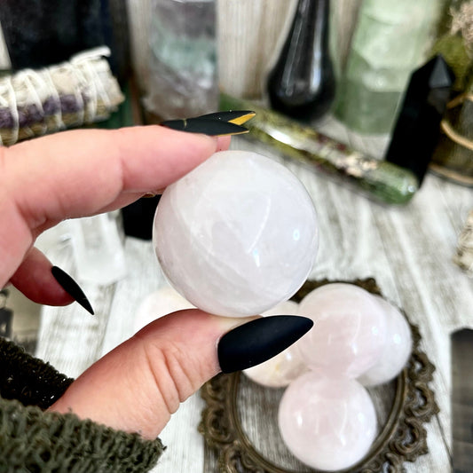 Small rose quartz crystal sphere from FoxlarkCrystals, showcasing a smooth, pink gemstone with natural crystal details.