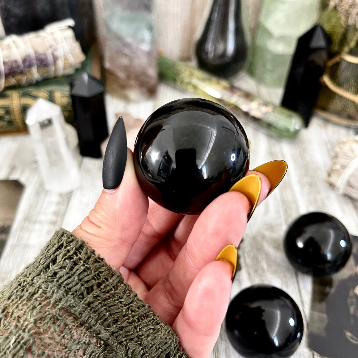 Small black obsidian crystal sphere from FoxlarkCrystals, showcasing a smooth, polished black stone with natural glassy luster.
